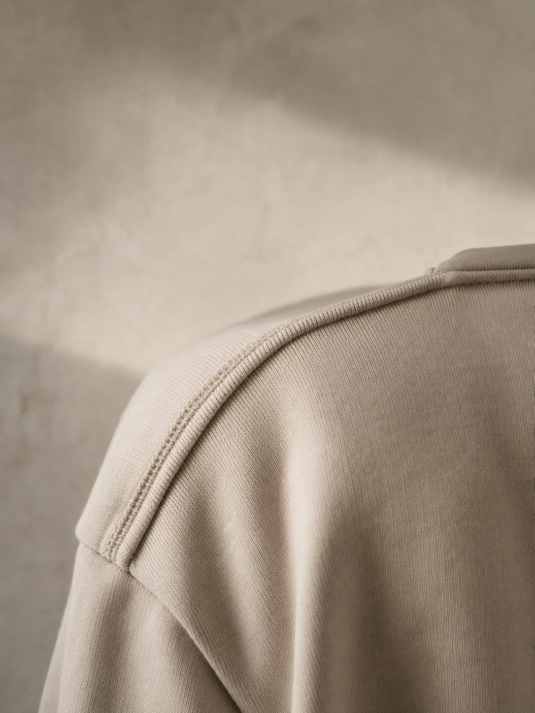 Close detail of a reinforced shoulder seam on a heavyweight cream Ondrea t-shirt.